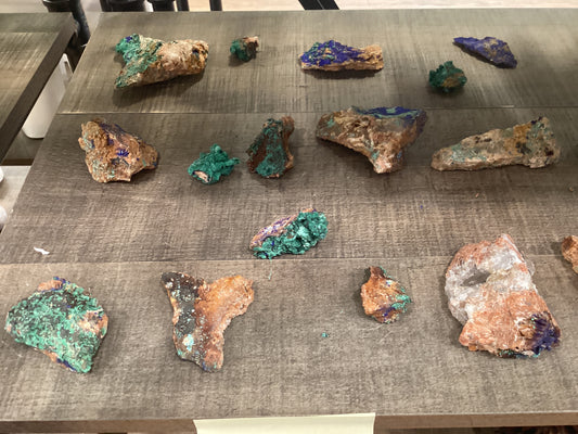 Assorted loose Azurite crystals on stones, with brilliant blue and green hues.