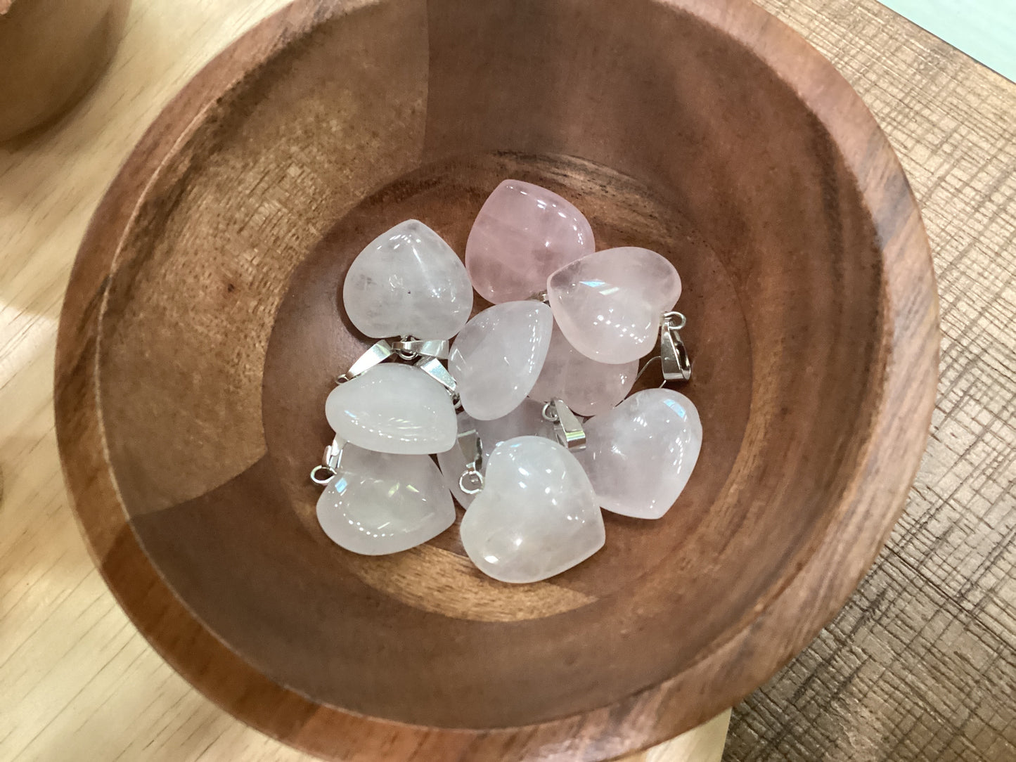 Heart-shaped rose quartz necklace charms with silver clasps.