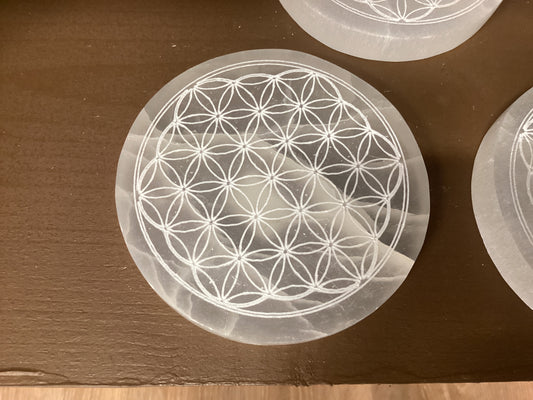 Semi-transparent white circular Selenite coaster with geometric design.