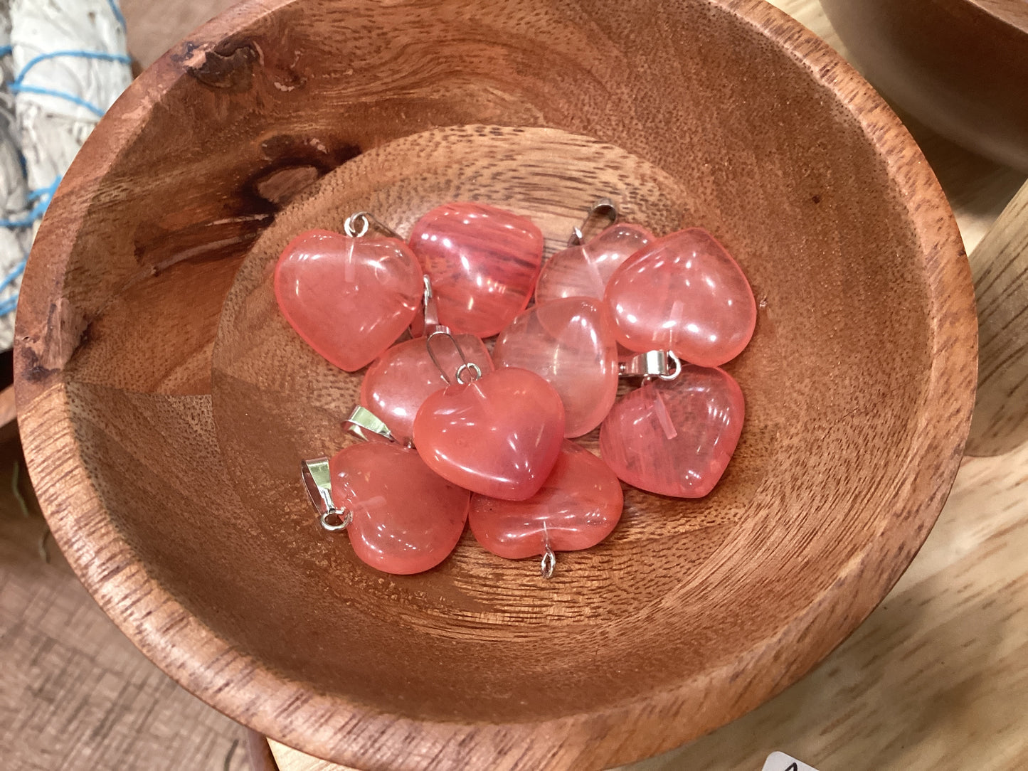 Heart-shaped cherry quartz necklace charms with silver clasps.