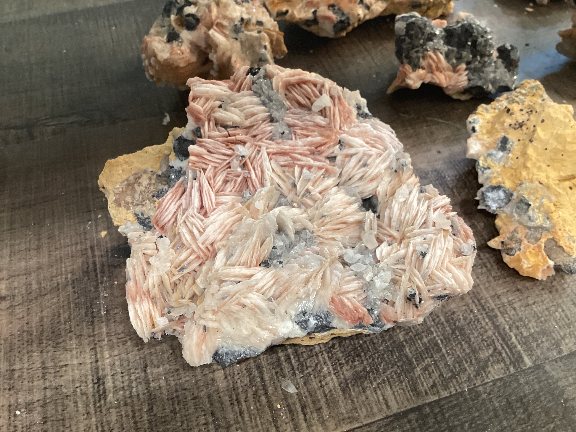 Assorted loose barite crystals on cerussite stones, in hues of pink, yellow, and and silver.