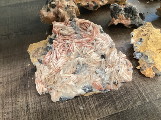 Assorted loose barite crystals on cerussite stones, in hues of pink, yellow, and and silver.